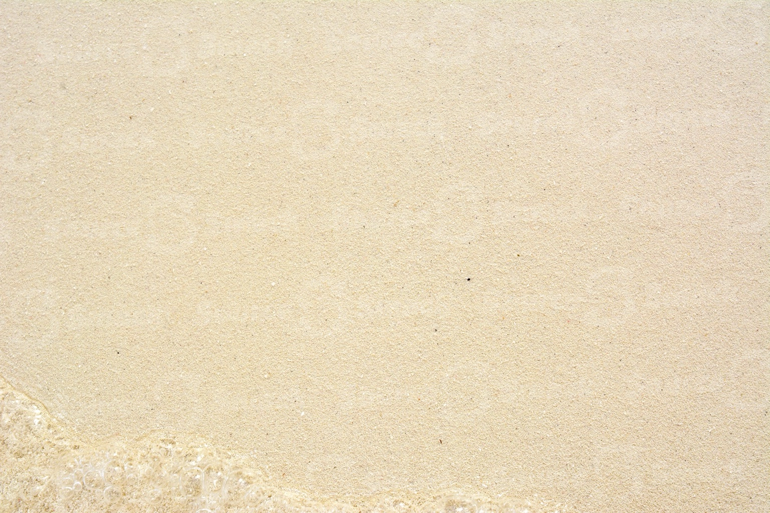 Closeup of beach sand with water in Mexico